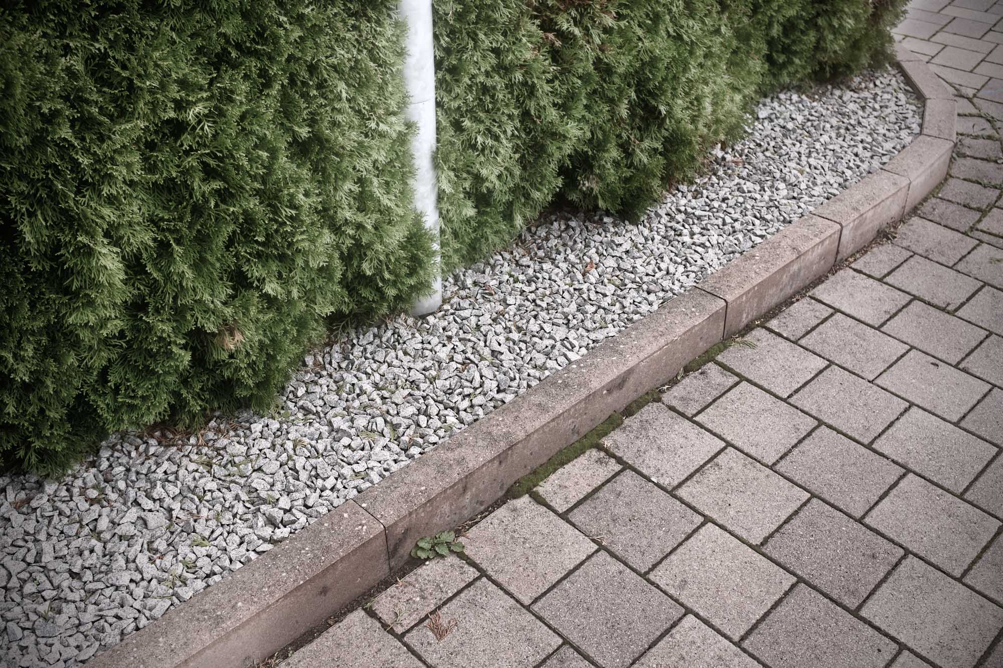 property edging with stones and hedge